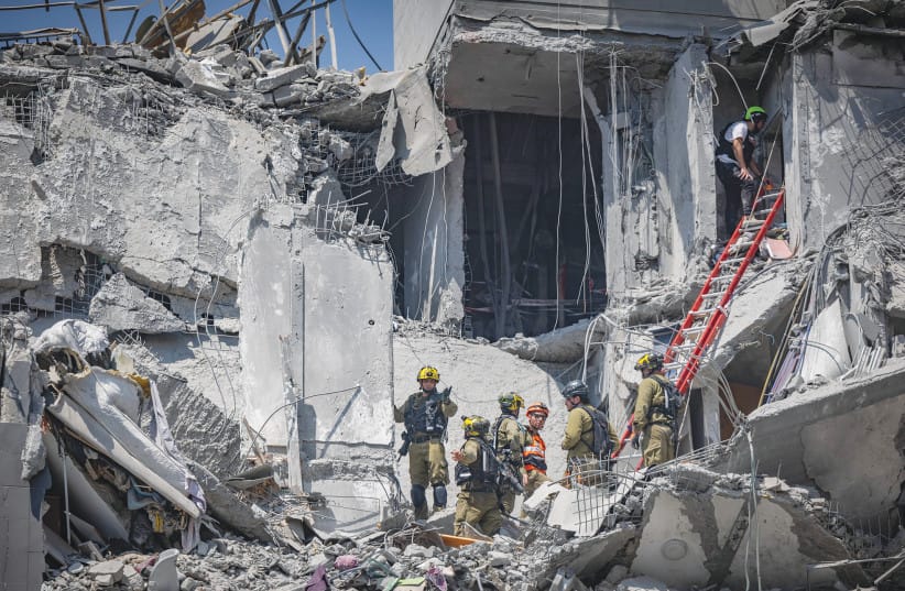 The scene where a ballistic missile fired from Iran hit and caused damage in Beersheba in June: Missiles may have stopped falling, but a far more insidious, silent, and sophisticated assault continues &ndash; cyber warfare and phishing, the writer warns. (credit: YONATAN SINDEL/FLASH 90)