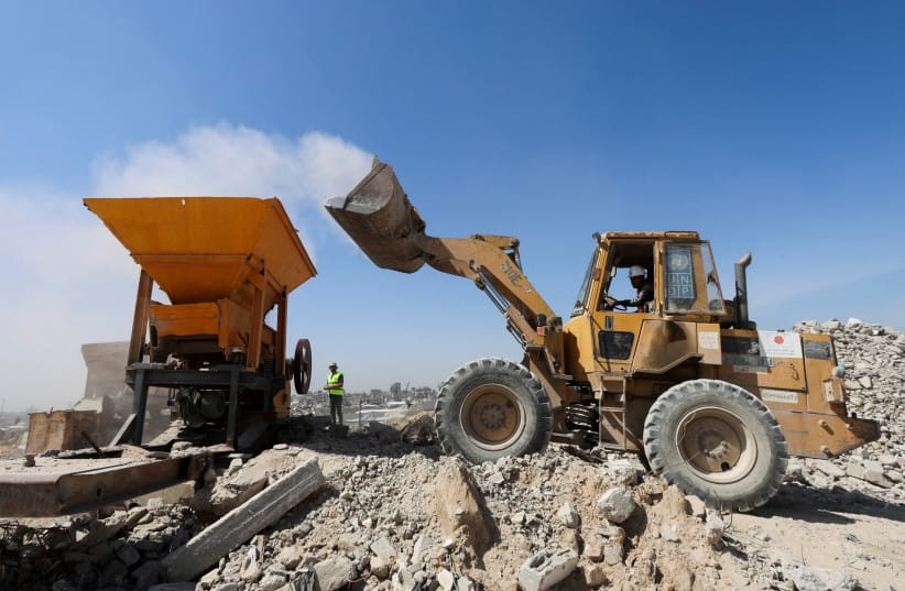 Heavy machinery crushes and moves rubble during sorting and recycling operations in Khan Younis, southern Gaza Strip, April 14, 2026.  (credit: REUTERS/Ramadan Abed)