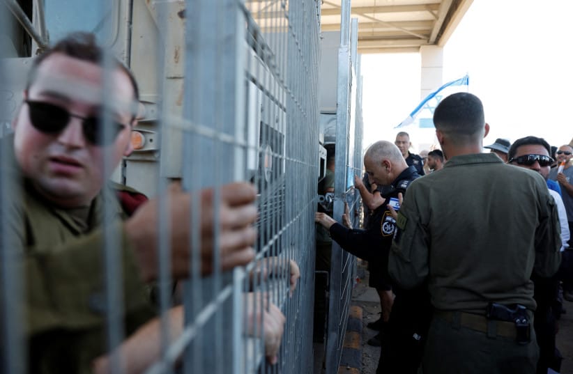 An Israeli police officer stands near a gate, while protesters gather outside Sde Teiman detention facility near Beersheba, in southern Israel, July 29, 2024 (credit: REUTERS/AMIR COHEN) An Israeli police officer stands near a gate, while protesters gather outside Sde Teiman detention facility near Beersheba, in southern Israel, July 29, 2024 (credit: REUTERS/AMIR COHEN)