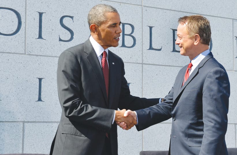 Shaking hands with then-US President Barack Obama at the dedication of the American Veterans Disabled for Life Memorial, in Washington, 2014. (credit: MIKE THEILER/REUTERS)