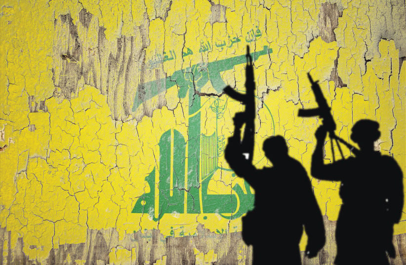 Hezbollah flag mural provides backdrop for gun-wielding shadows. (credit: SHUTTERSTOCK)