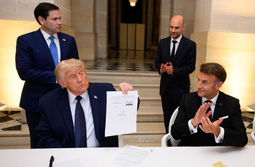 US President Donald Trump holds up the memorandum of understanding, signed by the US, and Iran, at the Palace of Versailles, in France.  (credit: SCREENSHOT/TRUTH SOCIAL)