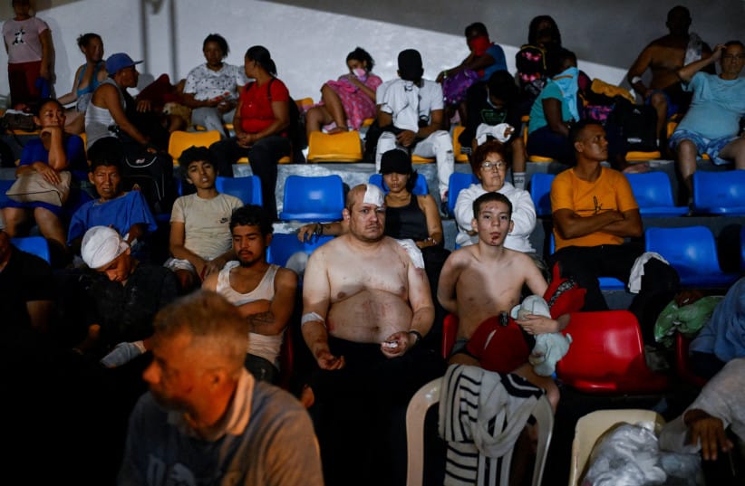 People gather as emergency services work at the site of a collapsed building after earthquakes hit the country, in Caracas, Venezuela, June 25, 2026.  (credit: REUTERS/LEONARDO FERNANDEZ VILORIA)