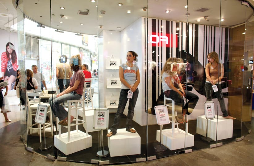 Women with price tags on their hands are displayed in the window of a store called Woman To Go in a shopping mall in Tel Aviv to raise awareness about and protest against the trafficking of women. (credit: NIR ELIAS/REUTERS) Women with price tags on their hands are displayed in the window of a store called Woman To Go in a shopping mall in Tel Aviv to raise awareness about and protest against the trafficking of women. (credit: NIR ELIAS/REUTERS)