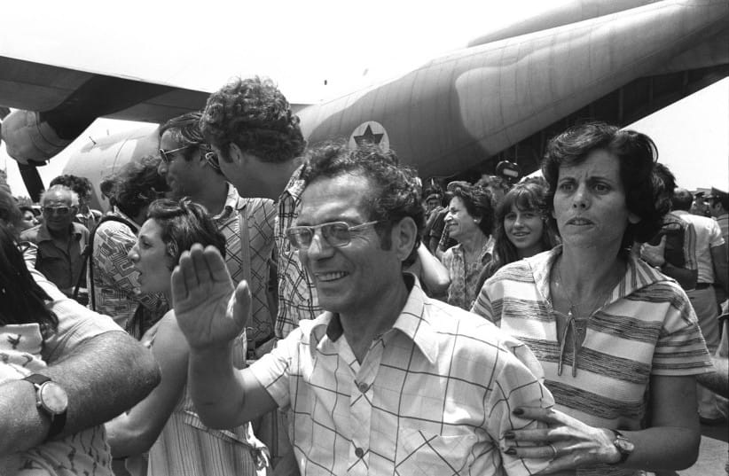 A joyous wave of the hand and a tense, searching look from hostages returning home to Israel. (credit: Moshe Milner/GPO)