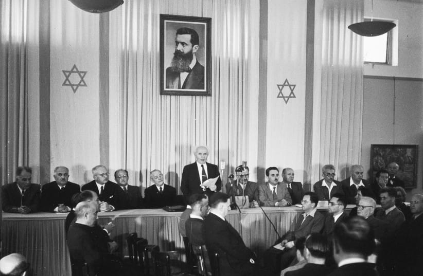 Founding father Herzl watches over David Ben-Gurion as he reads Israel&rsquo;s Declaration of Independence, Tel Aviv, May 14, 1948. (credit: Kluger Zoltan/GPO/Handout/Reuters)
