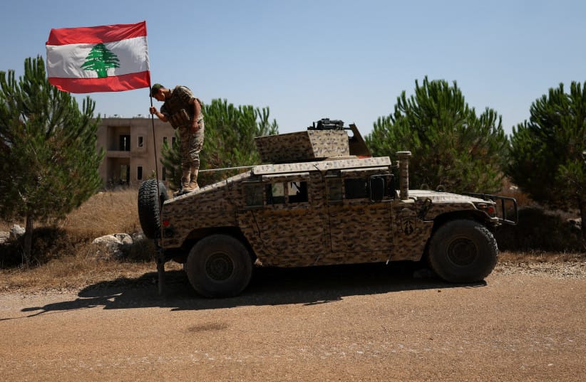 A soldier adjusts a Lebanese flag on an armored vehicle in Zawtar al-Gharbiyeh village, southern Lebanon, as Lebanese soldiers deploy in the area, July 21, 2026 (credit: REUTERS/ZOHRA BENSEMRA)