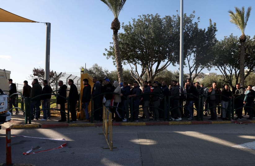  Palestinian workers wait to enter Ma'aleh Adumim, February 23, 2023; illustrative. (credit: REUTERS/AMMAR AWAD)