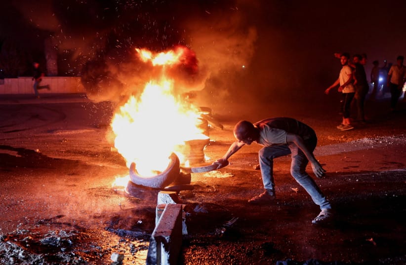 A protester in Aleppo burns tyres to protest the increase in fuel prices in Syria on the highway between Aleppo and Turkey, Syria, September 13, 2026. (credit: REUTERS/MAHMOUD HASSANO)