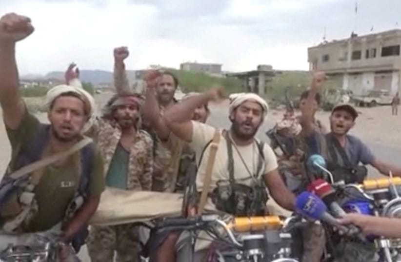 Men gesture in a screen grab from a video released September 11, 2026 and said to show Khaled bin Walid camp after Houthis captured the city of Mocha in Taiz Province. (credit: Al-Masirah TV/Handout via REUTERS)