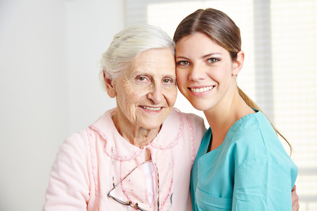 Caregiver embracing a smiling senior woman