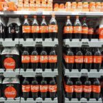 Coca-Cola bottles and cans on supermarket shelves