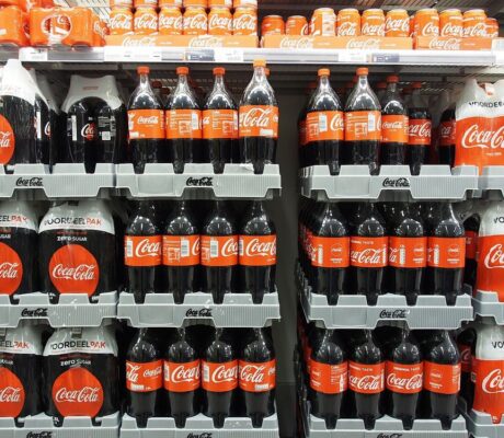 Coca-Cola bottles and cans on supermarket shelves