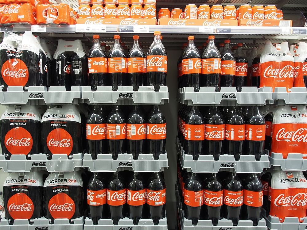 Coca-Cola bottles and cans on supermarket shelves