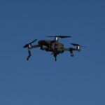 DJI Mavic 2 Pro drone in flight against a blue sky.