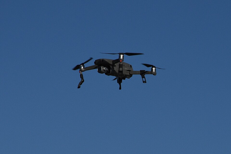 DJI Mavic 2 Pro drone in flight against a blue sky.