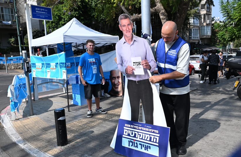 Democrats party member sets up a cardboard cutout of party Chairman Yair Golan as part of a final campaign to voters. (credit: AVSHALOM SASSONI/MAARIV)