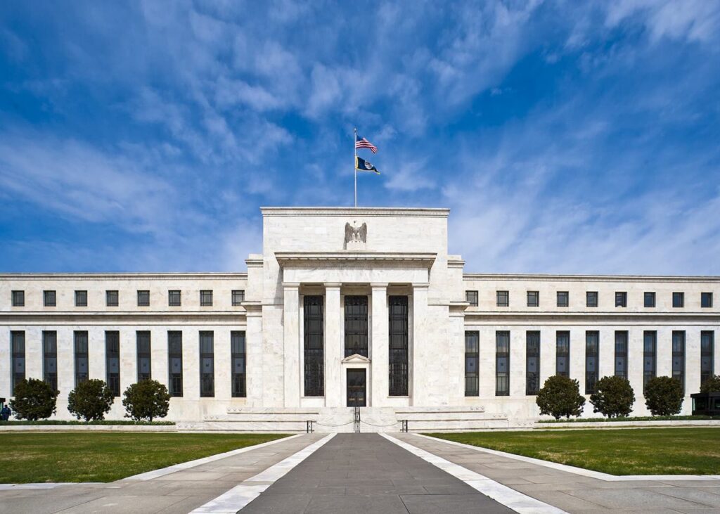 Federal Reserve Eccles Building with flags, archive photo, cropped. Federal Reserve / Wikimedia Commons, public domain.
