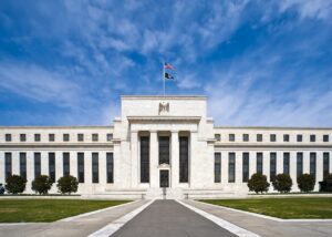 Federal Reserve Eccles Building with flags, archive photo, cropped. Federal Reserve / Wikimedia Commons, public domain.