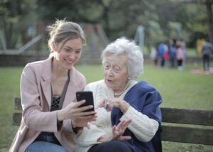 Archive two women using a smartphone together; not identified as caregivers or program participants
