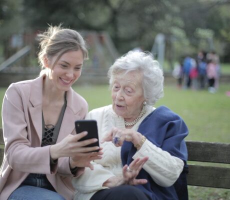 Archive two women using a smartphone together; not identified as caregivers or program participants