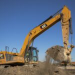 Archive photograph of a Caterpillar 330 excavator scooping dirt in November 2020; not a data-center site or a photograph from the current earnings announcement.