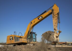 Archive photograph of a Caterpillar 330 excavator scooping dirt in November 2020; not a data-center site or a photograph from the current earnings announcement.