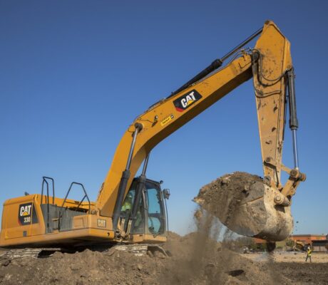 Archive photograph of a Caterpillar 330 excavator scooping dirt in November 2020; not a data-center site or a photograph from the current earnings announcement.