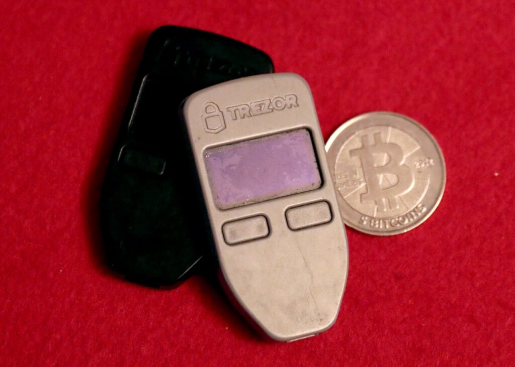 Two hardware wallets and a physical Bitcoin medallion in July 2019. Archive photo, not Binance equipment.