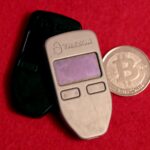 Two hardware wallets and a physical Bitcoin medallion in July 2019. Archive photo, not Binance equipment.