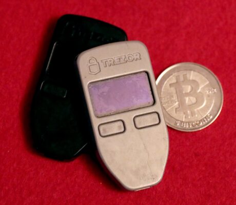 Two hardware wallets and a physical Bitcoin medallion in July 2019. Archive photo, not Binance equipment.