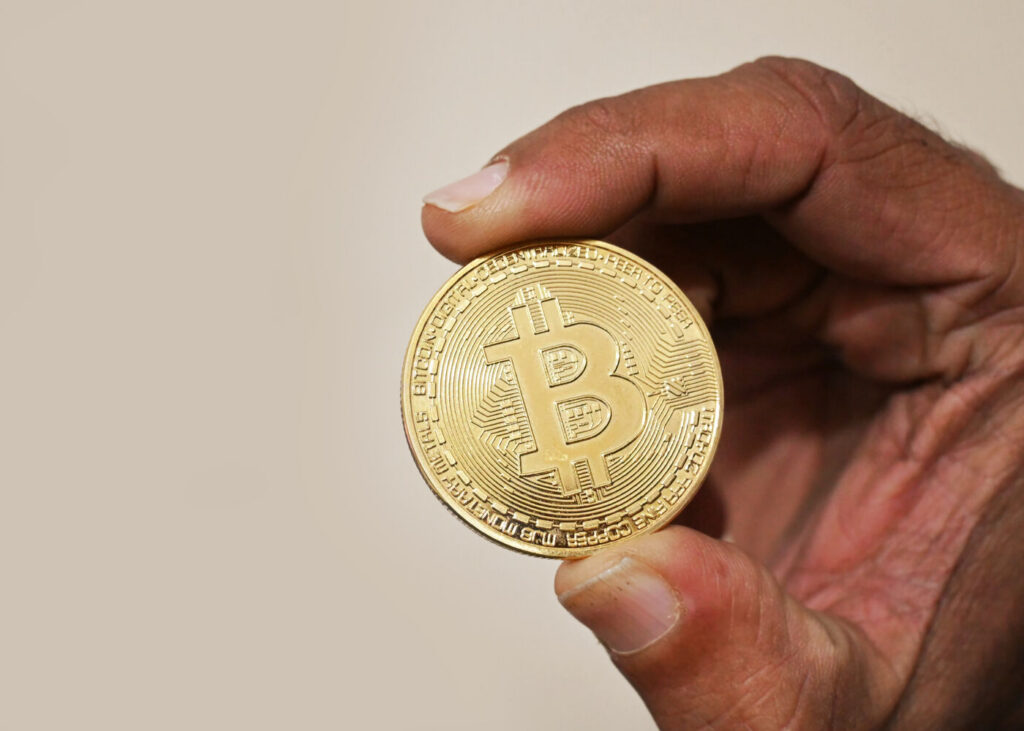 Archive photo: a physical Bitcoin coin held between two fingers