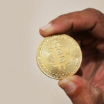 Archive photo: a physical Bitcoin coin held between two fingers