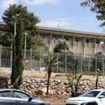 Archive photo: the Knesset building in Jerusalem, September 3, 2025, with fence, trees and cars in the foreground. Lizzy Shaanan / PikiWiki Israel, CC BY 2.5, cropped. Not the 2026 count.