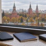 U.S. desk flag, phone, notebook and power bank beside a window.