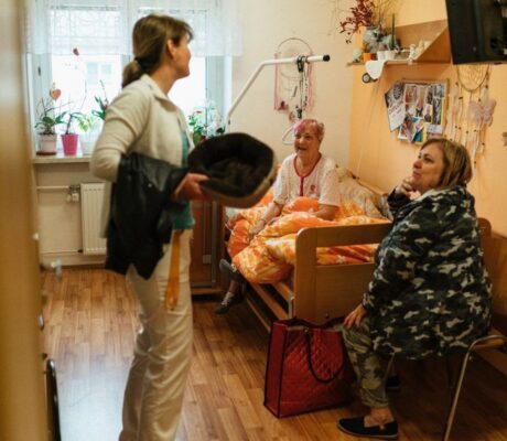A caregiver and older adults in a residential care setting. Illustrative archive, not a U.S. facility assessed by CMS.