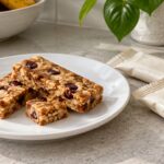 Snack bars on a plate beside plain wrappers.