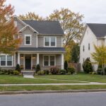 Detached homes with autumn trees beside a residential street.